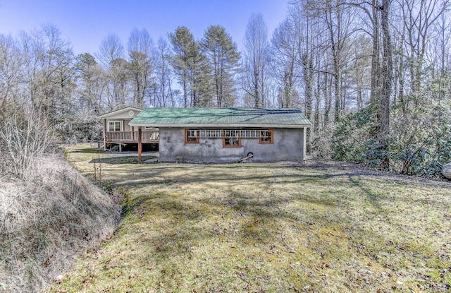 view of front of house featuring a front yard, metal roof, and a wooden deck