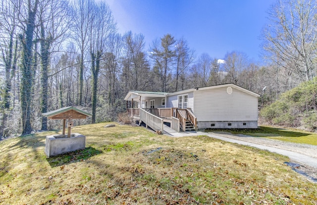 view of home's exterior featuring stairway, crawl space, a wooden deck, and a lawn