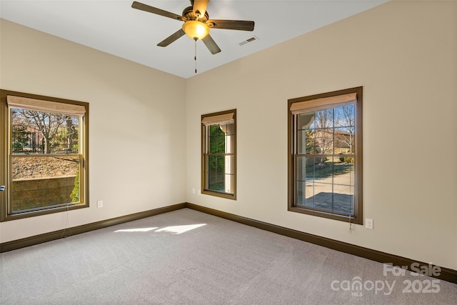 spare room featuring baseboards, visible vents, ceiling fan, and carpet flooring