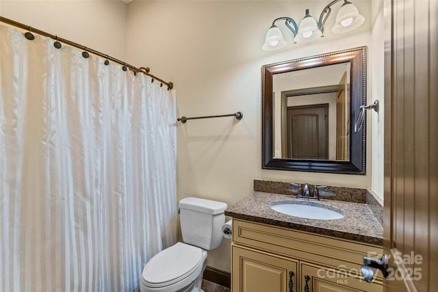 bathroom featuring toilet, a shower with shower curtain, and vanity