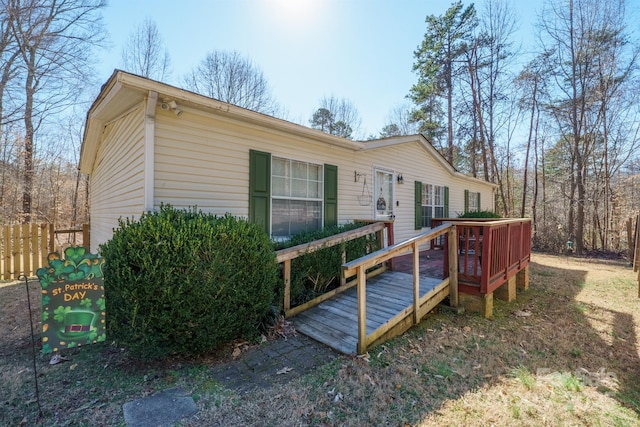 view of front facade featuring fence and a wooden deck