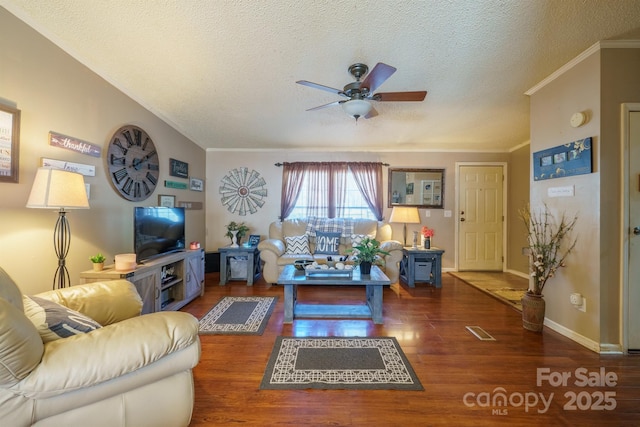 living area featuring dark wood-style flooring, crown molding, a ceiling fan, a textured ceiling, and baseboards