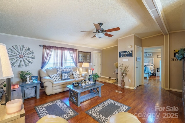 living room with a textured ceiling, ceiling fan, dark wood-style flooring, baseboards, and crown molding