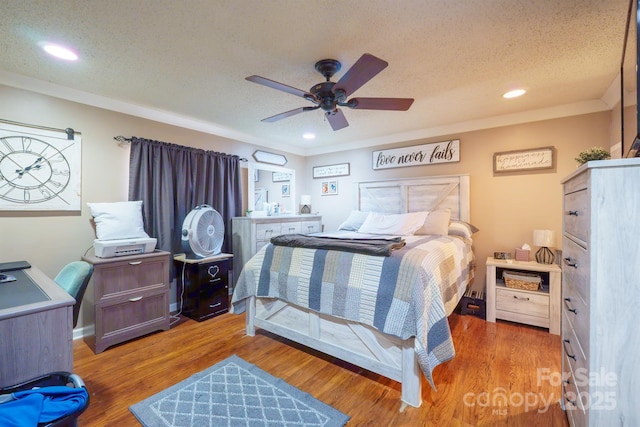 bedroom featuring a ceiling fan, recessed lighting, a textured ceiling, and wood finished floors