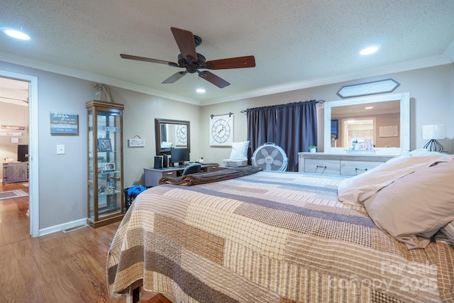 bedroom with light wood-style floors, crown molding, baseboards, and a textured ceiling