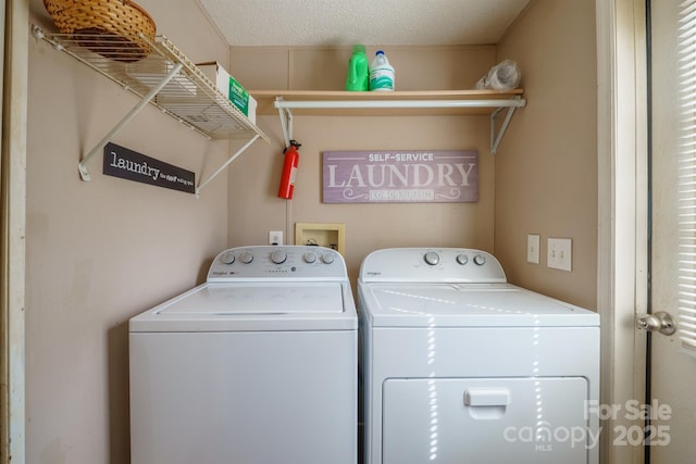 washroom featuring laundry area, washer and clothes dryer, and a textured ceiling