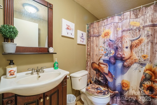 bathroom featuring a shower with shower curtain, a textured ceiling, toilet, and vanity