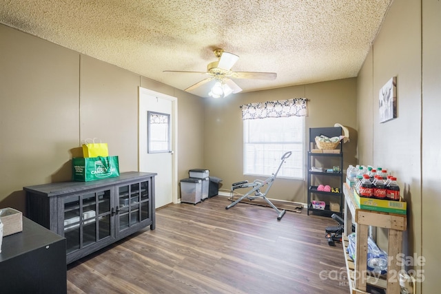 office space featuring baseboards, a textured ceiling, a ceiling fan, and dark wood-type flooring