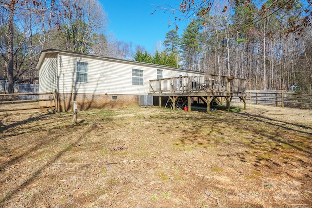 rear view of house featuring a deck, crawl space, a fenced backyard, and central air condition unit