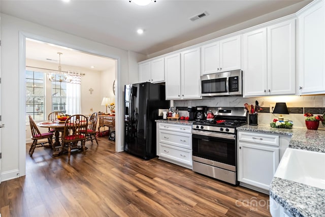 kitchen featuring visible vents, backsplash, appliances with stainless steel finishes, dark wood-type flooring, and white cabinetry