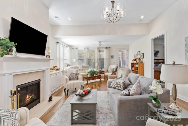 living area featuring light wood-style flooring, a high end fireplace, visible vents, and recessed lighting