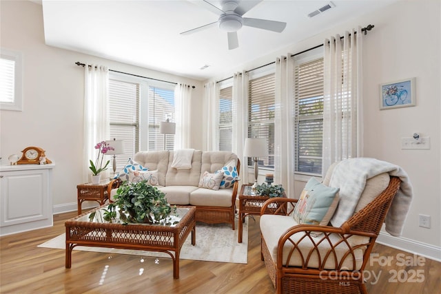 sitting room featuring a ceiling fan, baseboards, visible vents, and light wood finished floors