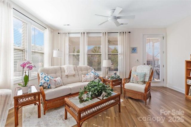 interior space with light wood-type flooring, visible vents, ceiling fan, and baseboards