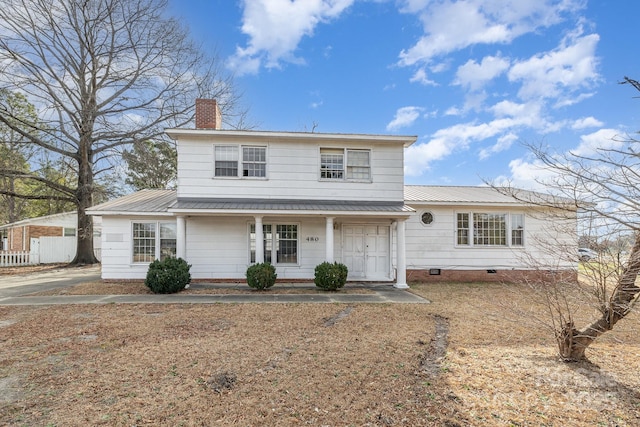 traditional home with metal roof, a porch, a chimney, and crawl space