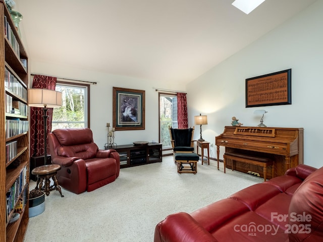 living area featuring lofted ceiling with skylight and carpet flooring