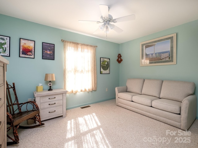 living room featuring ceiling fan, visible vents, and baseboards