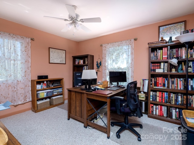 home office with carpet floors, a healthy amount of sunlight, and a ceiling fan