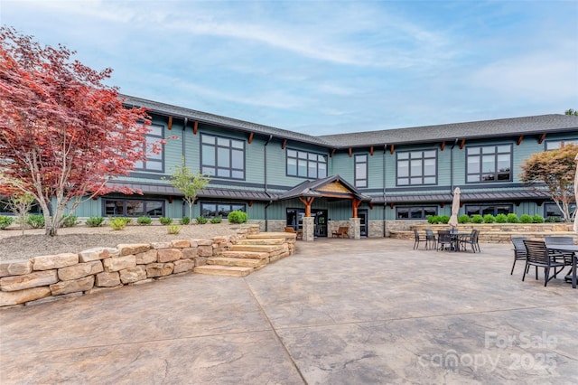 view of front facade featuring outdoor dining space and a patio area