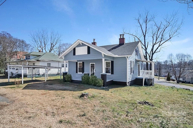 view of front of house with a chimney, a front lawn, and roof with shingles