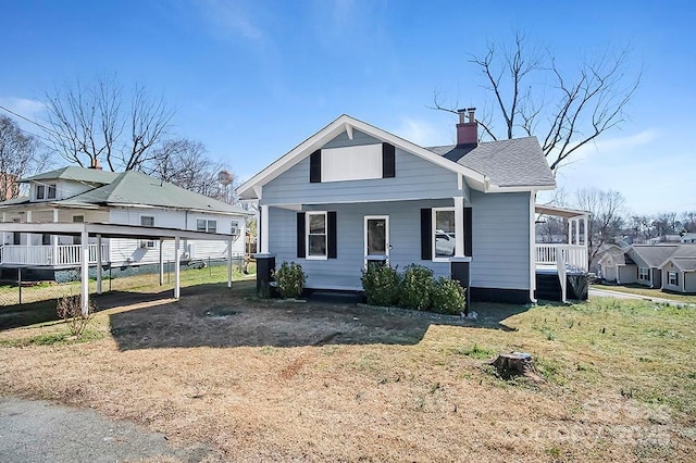 view of front of home featuring a shingled roof, a chimney, and a carport