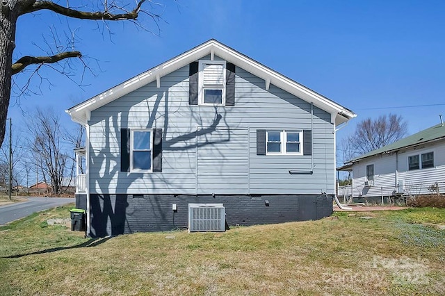 rear view of property featuring crawl space, cooling unit, and a yard