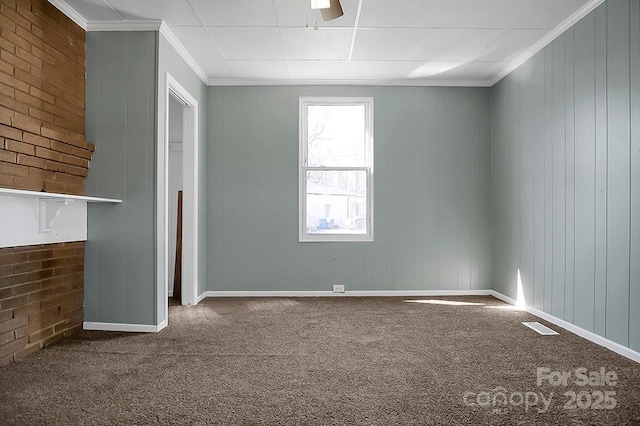 carpeted empty room featuring visible vents, crown molding, and baseboards