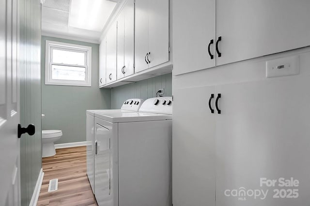 laundry room featuring cabinet space, visible vents, baseboards, light wood-style floors, and washing machine and dryer