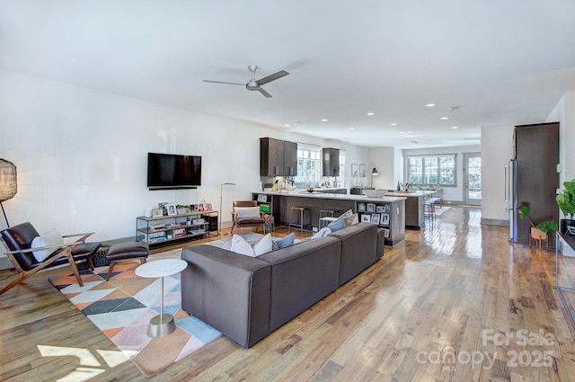 living room with a ceiling fan, light wood-type flooring, and recessed lighting