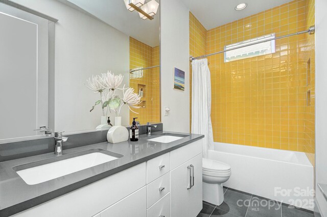 bathroom featuring shower / tub combo, a sink, toilet, and tile patterned floors