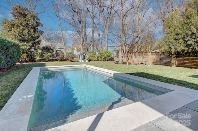 view of swimming pool with a yard, an outdoor structure, a fenced backyard, and a fenced in pool