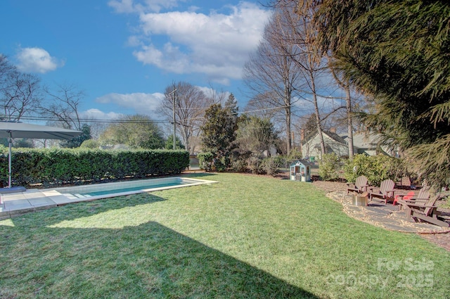 view of yard with a storage shed, a patio area, an outdoor structure, and a fenced in pool