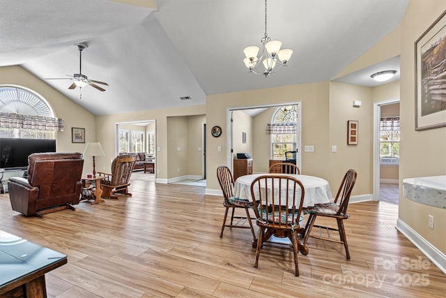 dining room featuring light wood-type flooring, visible vents, lofted ceiling, and baseboards