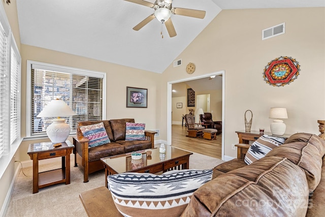 living area with ceiling fan, high vaulted ceiling, visible vents, and baseboards