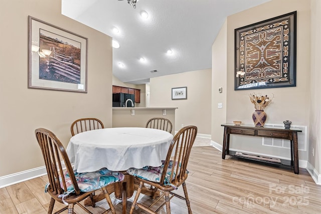 dining area featuring recessed lighting, visible vents, baseboards, vaulted ceiling, and light wood finished floors