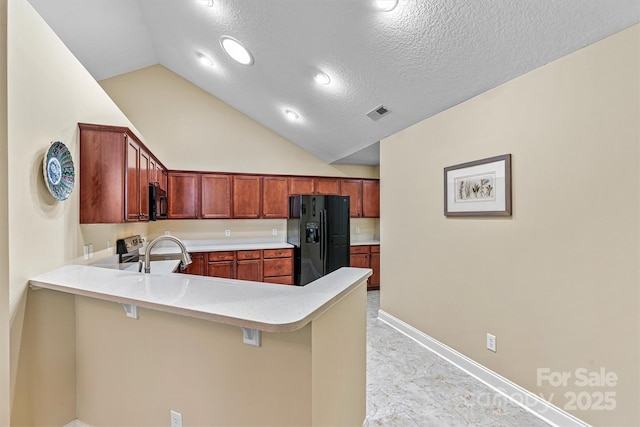 kitchen with visible vents, light countertops, black appliances, a peninsula, and baseboards