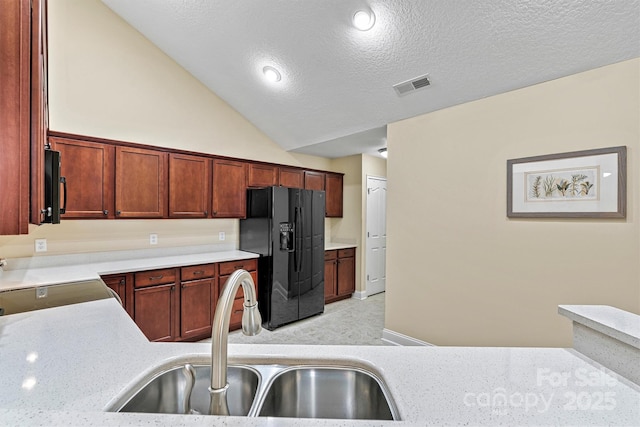 kitchen featuring light countertops, visible vents, vaulted ceiling, a sink, and black appliances