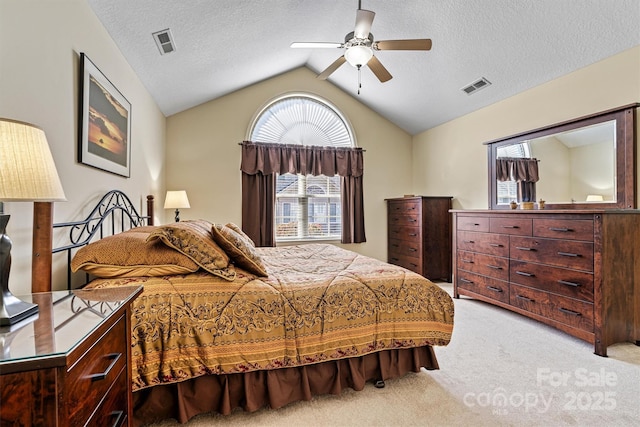 bedroom with light carpet, visible vents, vaulted ceiling, and a textured ceiling