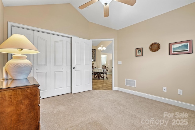 bedroom featuring baseboards, visible vents, lofted ceiling, carpet floors, and a closet