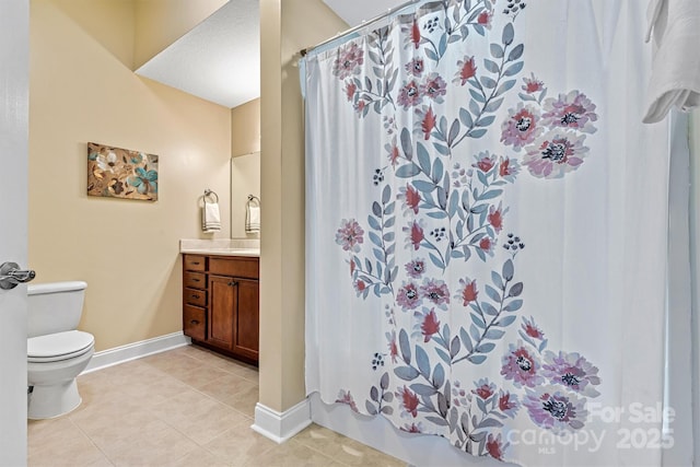 bathroom with toilet, tile patterned flooring, baseboards, and vanity