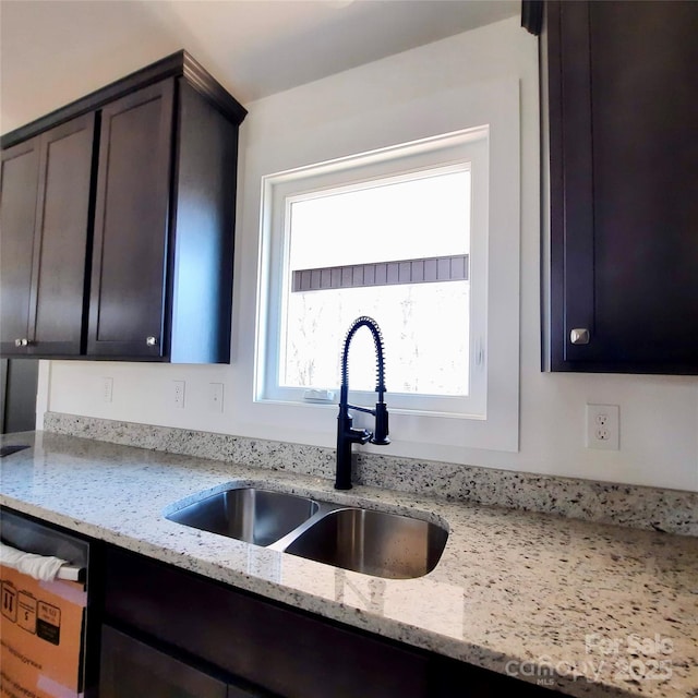 kitchen with light stone counters and a sink