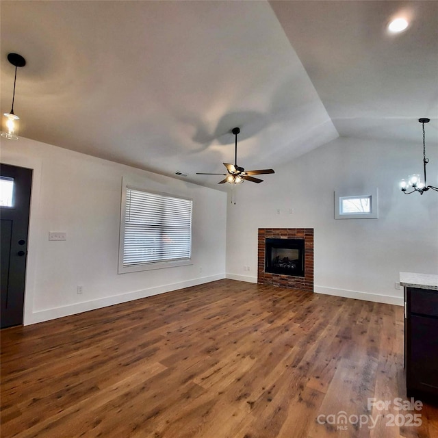 unfurnished living room featuring baseboards, a ceiling fan, lofted ceiling, dark wood-style floors, and a fireplace