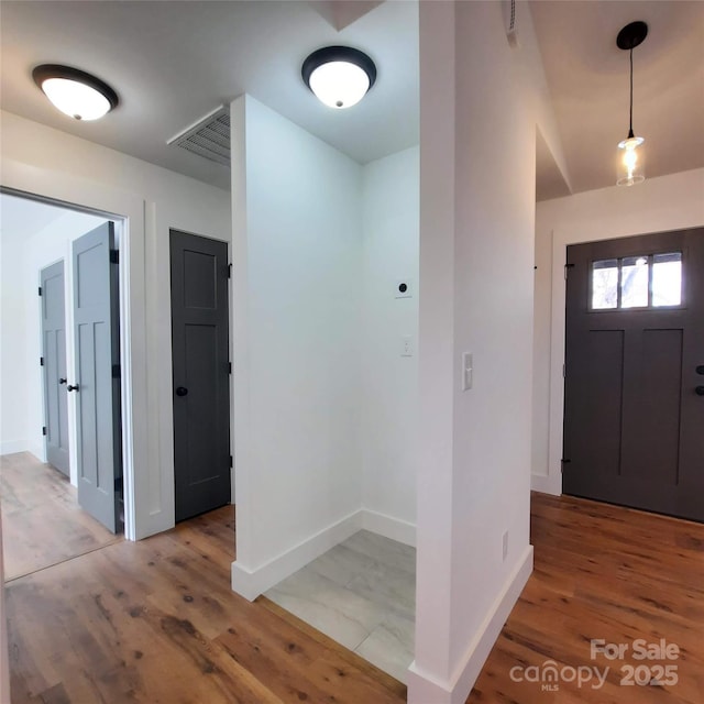 entrance foyer with wood finished floors, visible vents, and baseboards