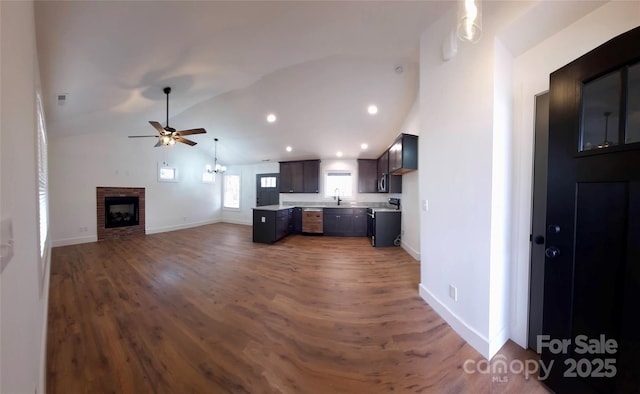 kitchen with dark wood-style flooring, a fireplace, light countertops, open floor plan, and range