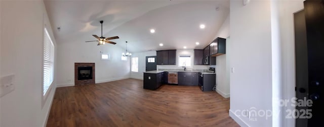 kitchen featuring stove, a fireplace, wood finished floors, open floor plan, and light countertops