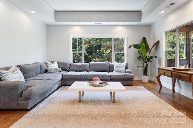 living room with baseboards, visible vents, wood finished floors, and recessed lighting