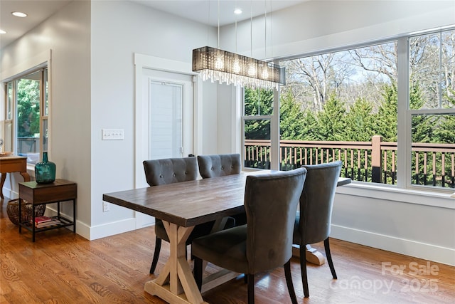 dining area with an inviting chandelier, baseboards, wood finished floors, and recessed lighting