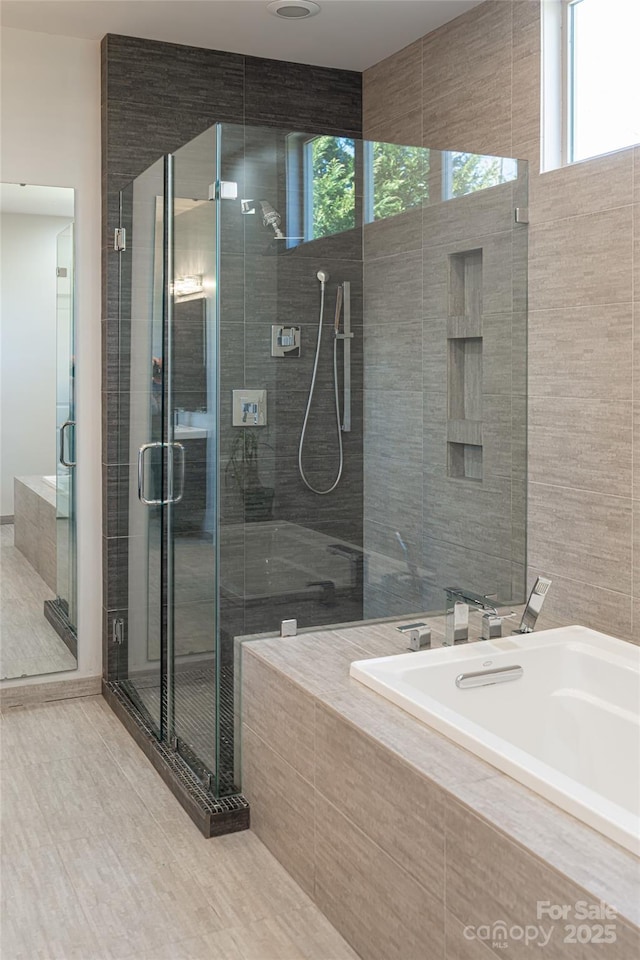 bathroom with a stall shower, plenty of natural light, and a garden tub