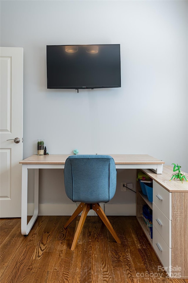 office featuring built in desk, wood finished floors, and baseboards