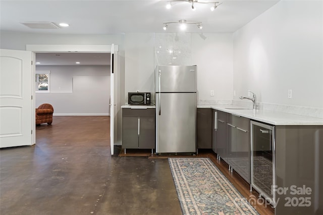 kitchen with wine cooler, light countertops, visible vents, freestanding refrigerator, and a sink