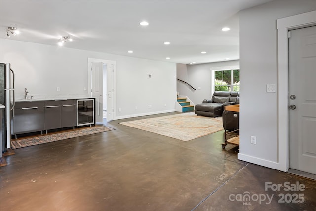 interior space with baseboards, wine cooler, stairway, finished concrete floors, and recessed lighting